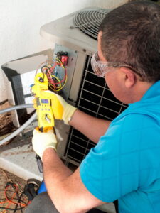 technician-checking-multimeter-at-AC-unit