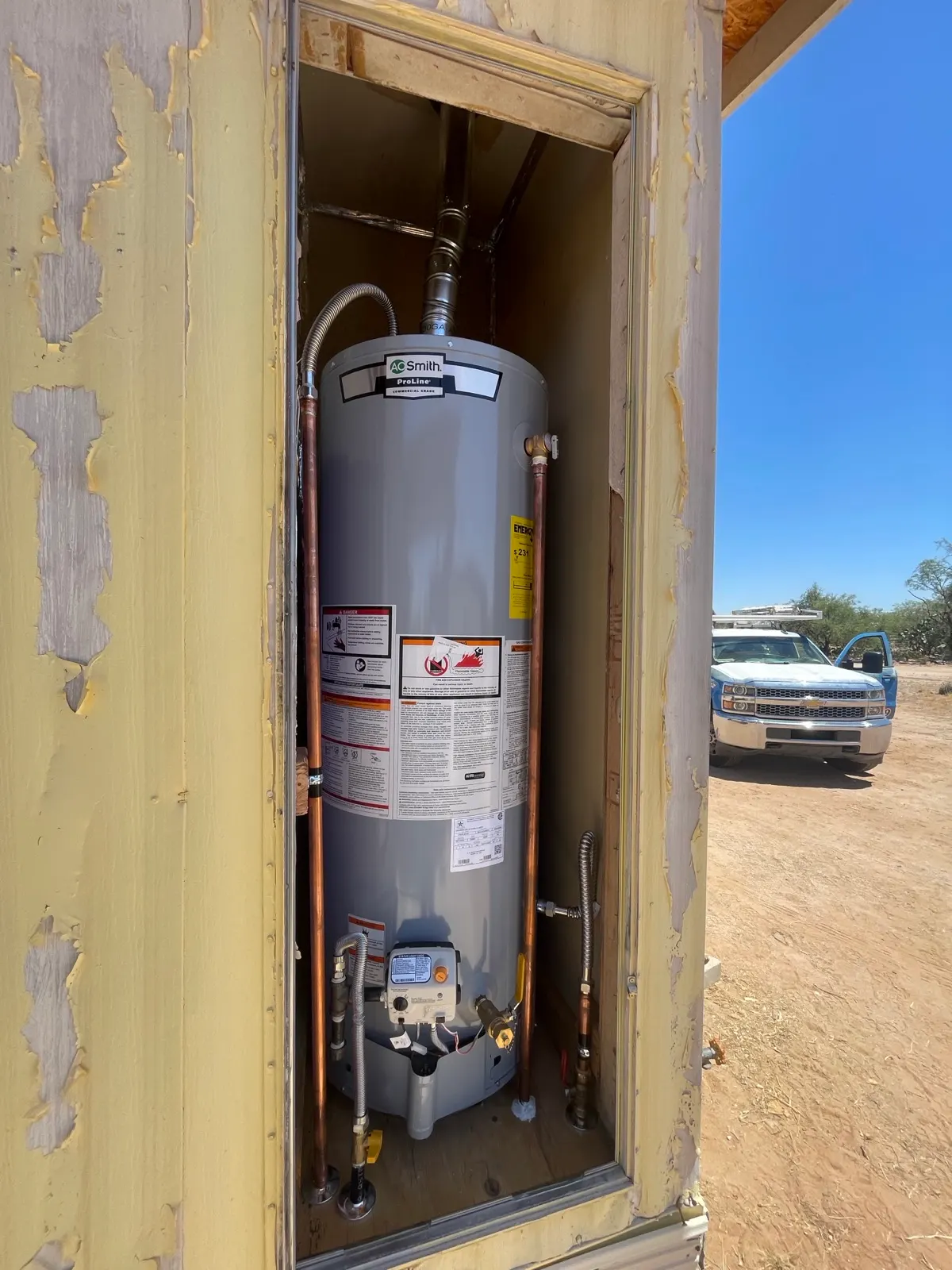 Finished gas water heater installed in an exterior closet with gas flex and copper lines
