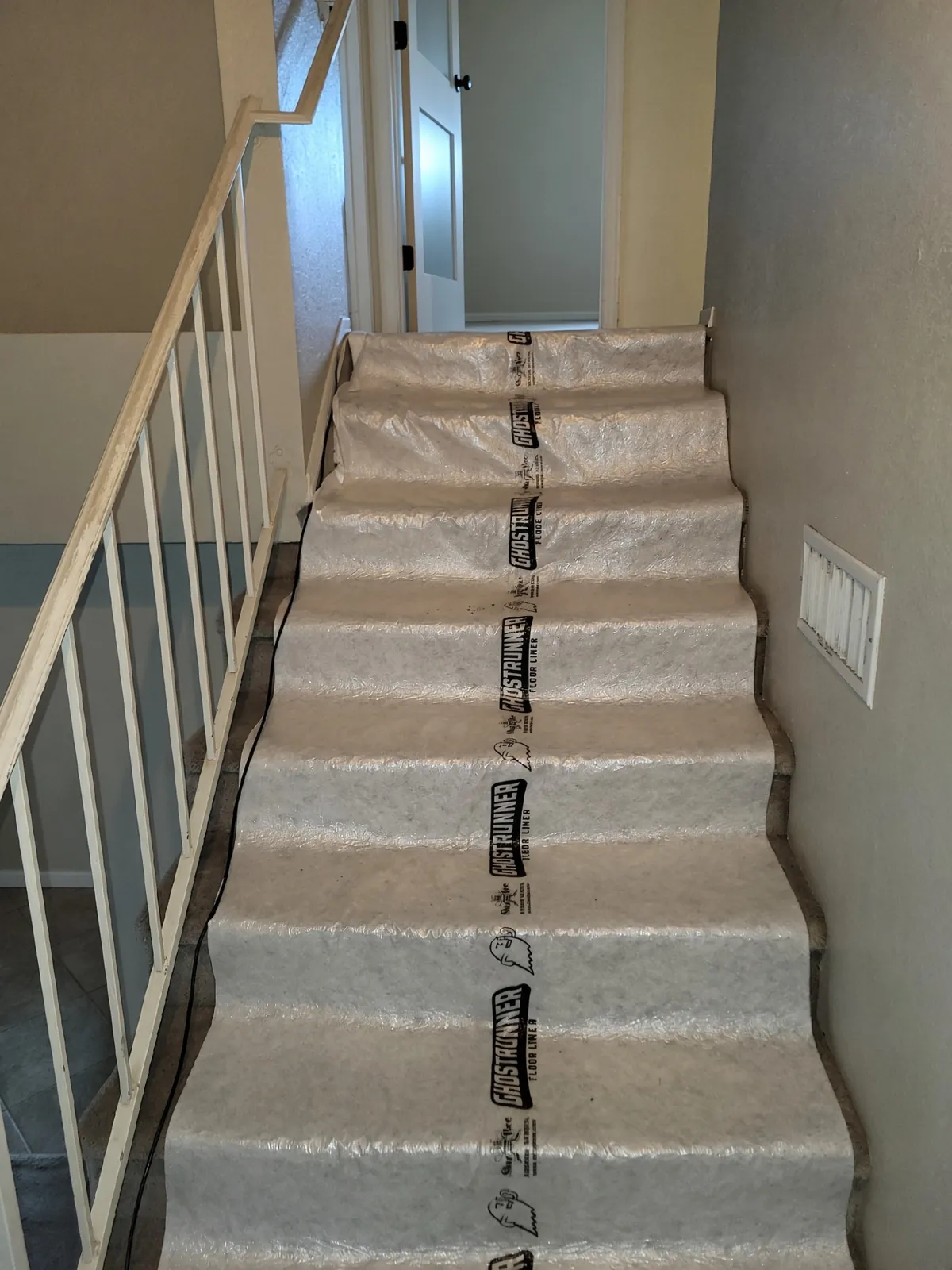Floor-protection runners through the entry before a larger plumbing job begins