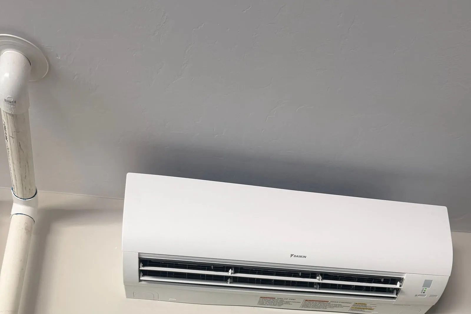 The white wall-mounted ductless head high on the garage wall.
