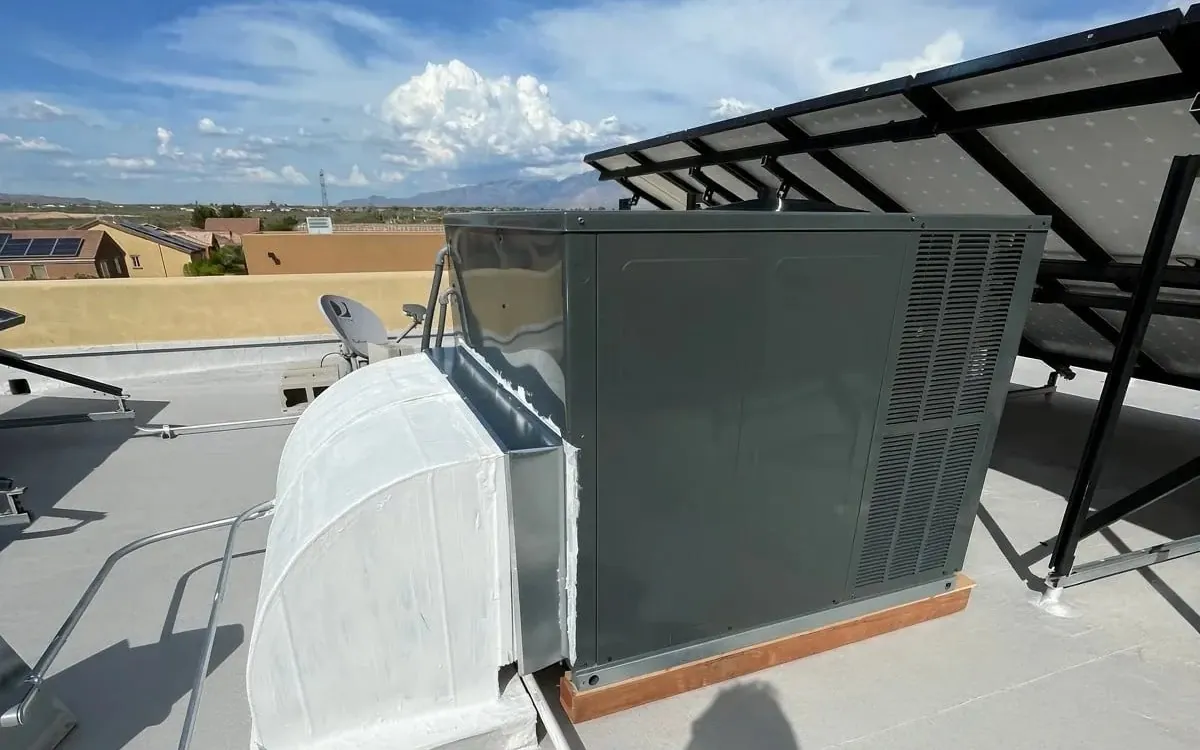 The duct transition and curb sealed and coated white to match the roof.