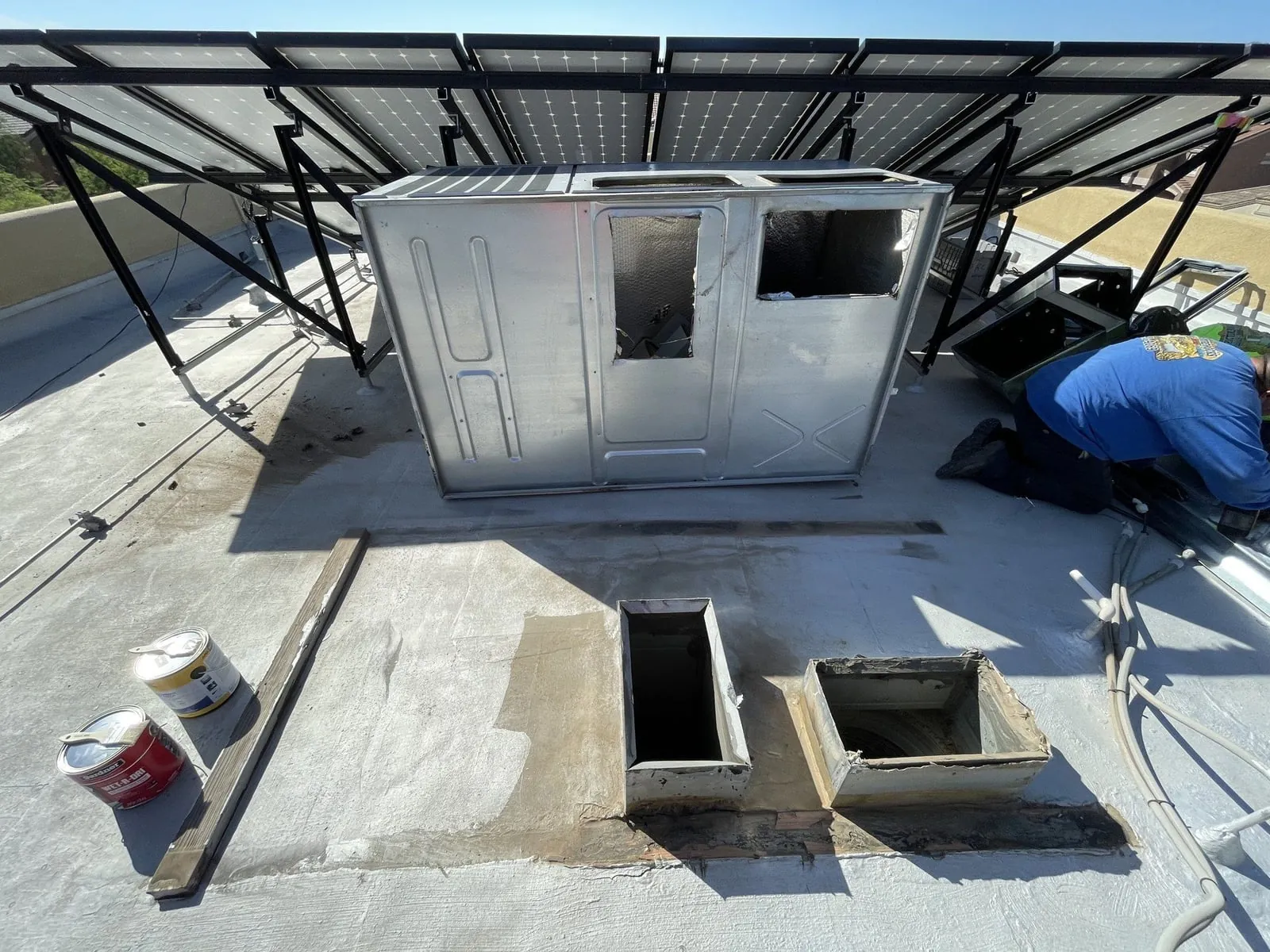 The roof with the old unit set aside and the supply and return openings exposed.