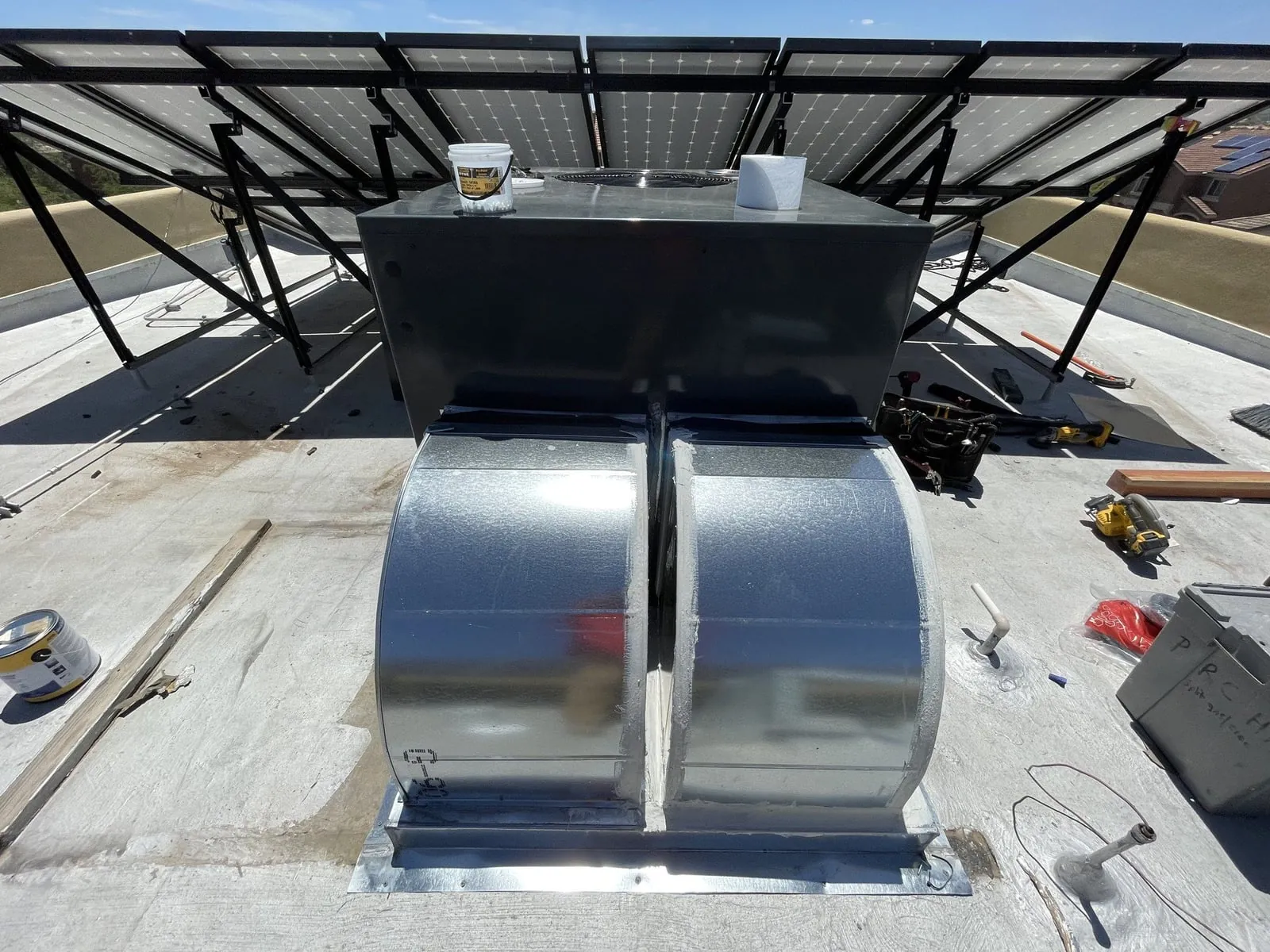 New sheet-metal duct transitions installed between the new unit and the roof curb.