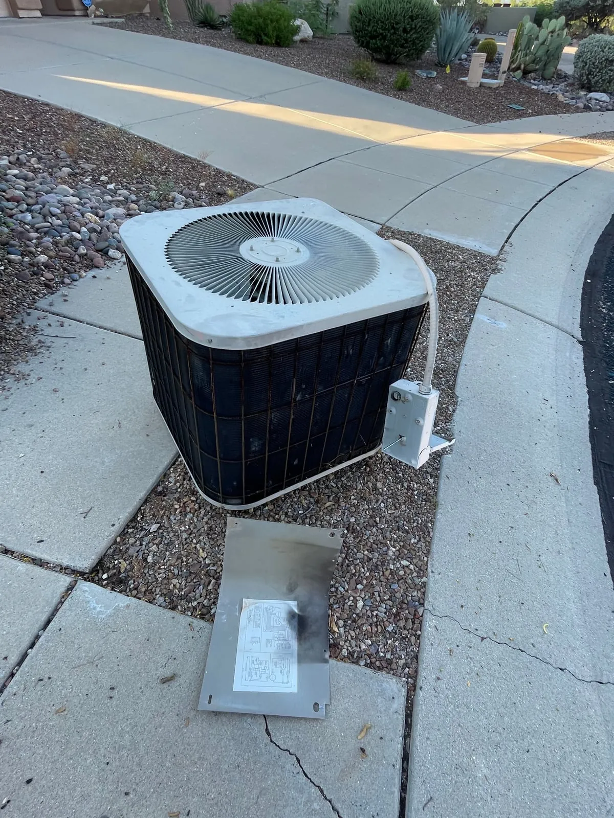 The old outdoor AC unit pulled off its pad and set on the walkway.