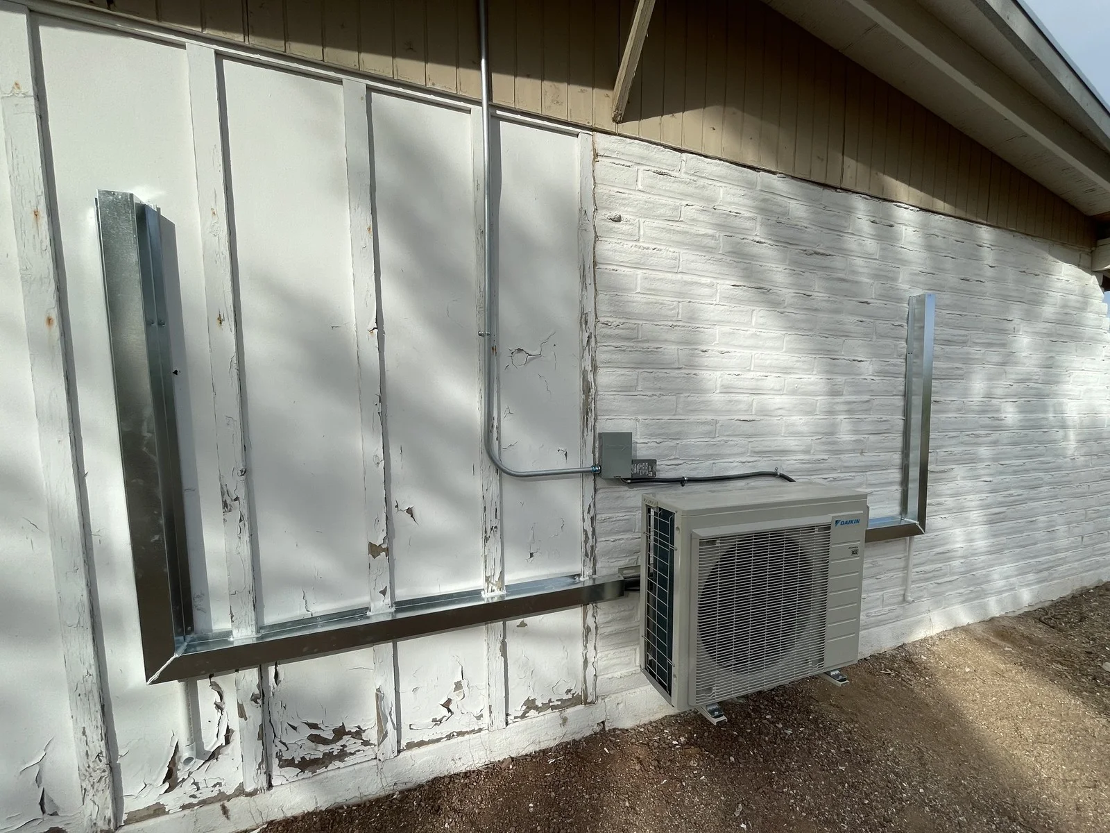 An outdoor ductless unit with covered line-set runs against the exterior wall.