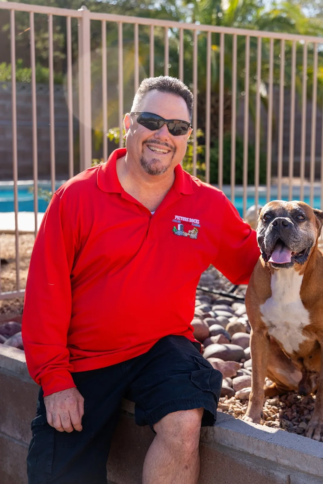 The Picture Rocks owner in a red company polo with his boxer dog